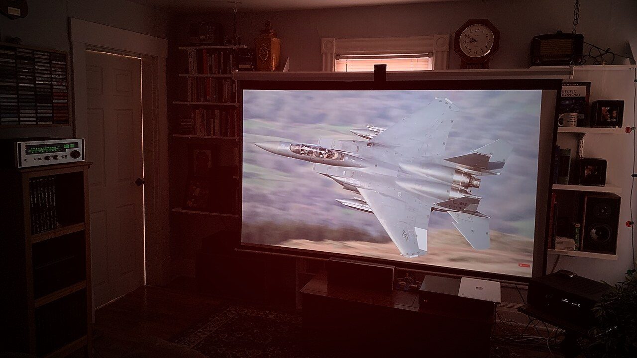 Living room with a big projector screen showing a film — the kind of setup KemoTV streams to