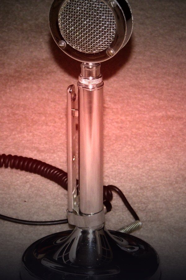 Vintage stage microphone in warm light — Laugh Track comedy on KemoTV